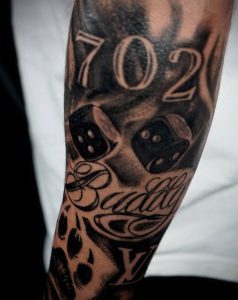 Black and grey Las Vegas “702” dice tattoo on forearm by Henry Fuentes at Legendary Tattoos in Las Vegas, Nevada