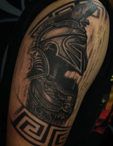 Black and grey Spartan warrior tattoo on upper arm by Henry Fuentes at Legendary Tattoos in Las Vegas, Nevada