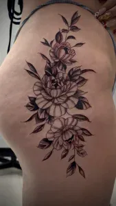 A woman's hip side with a tattoo of flowers by Legendary Tattoos in Las Vegas, Nevada.
