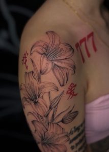 Shoulder tattoo and start of sleeve featuring flowers