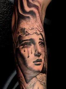 Black and Grey realism tattoo of Mother Mary crying by Legendary Tattoos in Las Vegas.