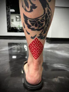 Black and grey geometric red ink contrast tattoo on forearm at Legendary Tattoos in Las Vegas, Nevada